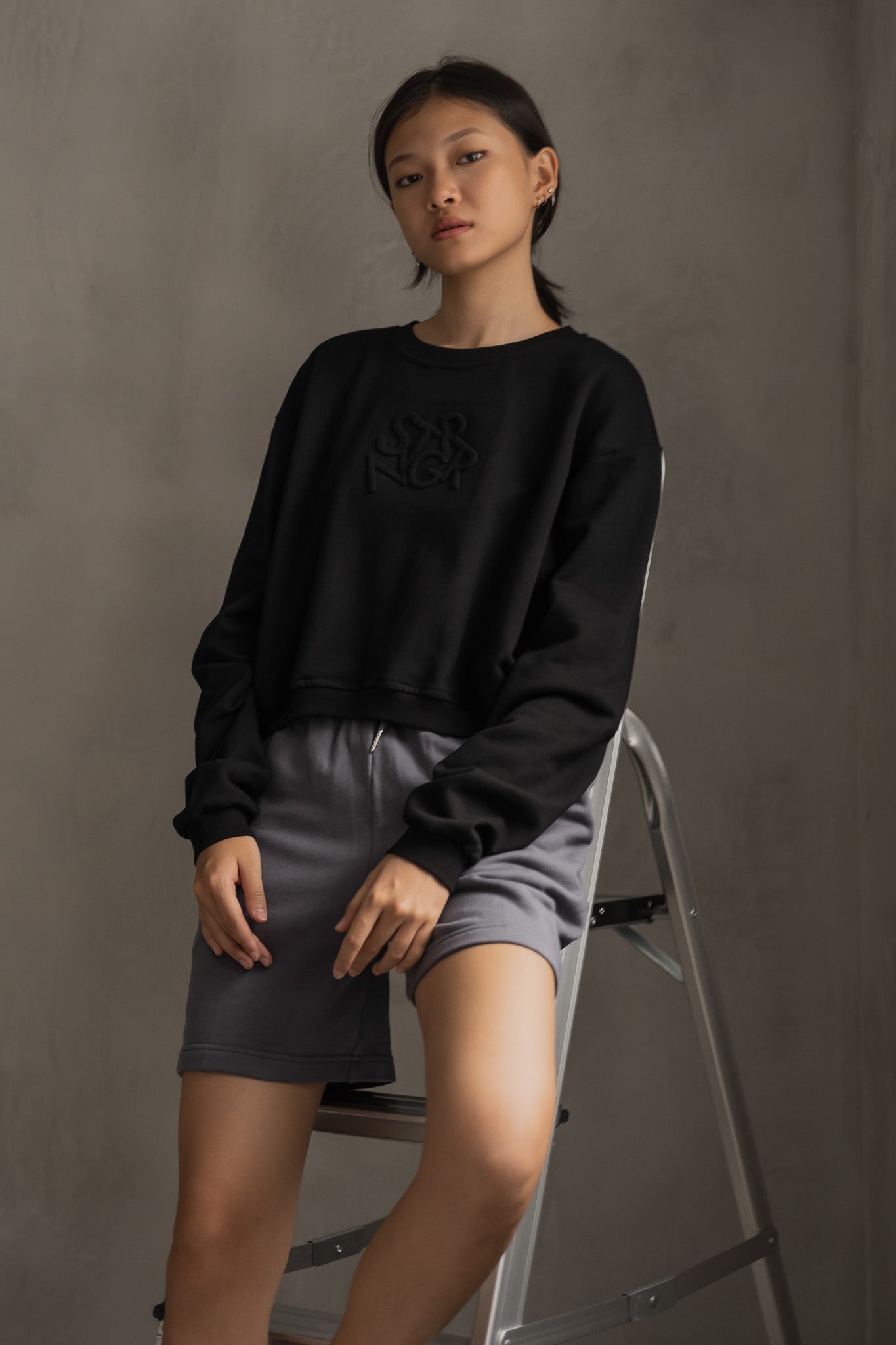 STRANGER Embossed Logo Cropped Sweatshirt in Black